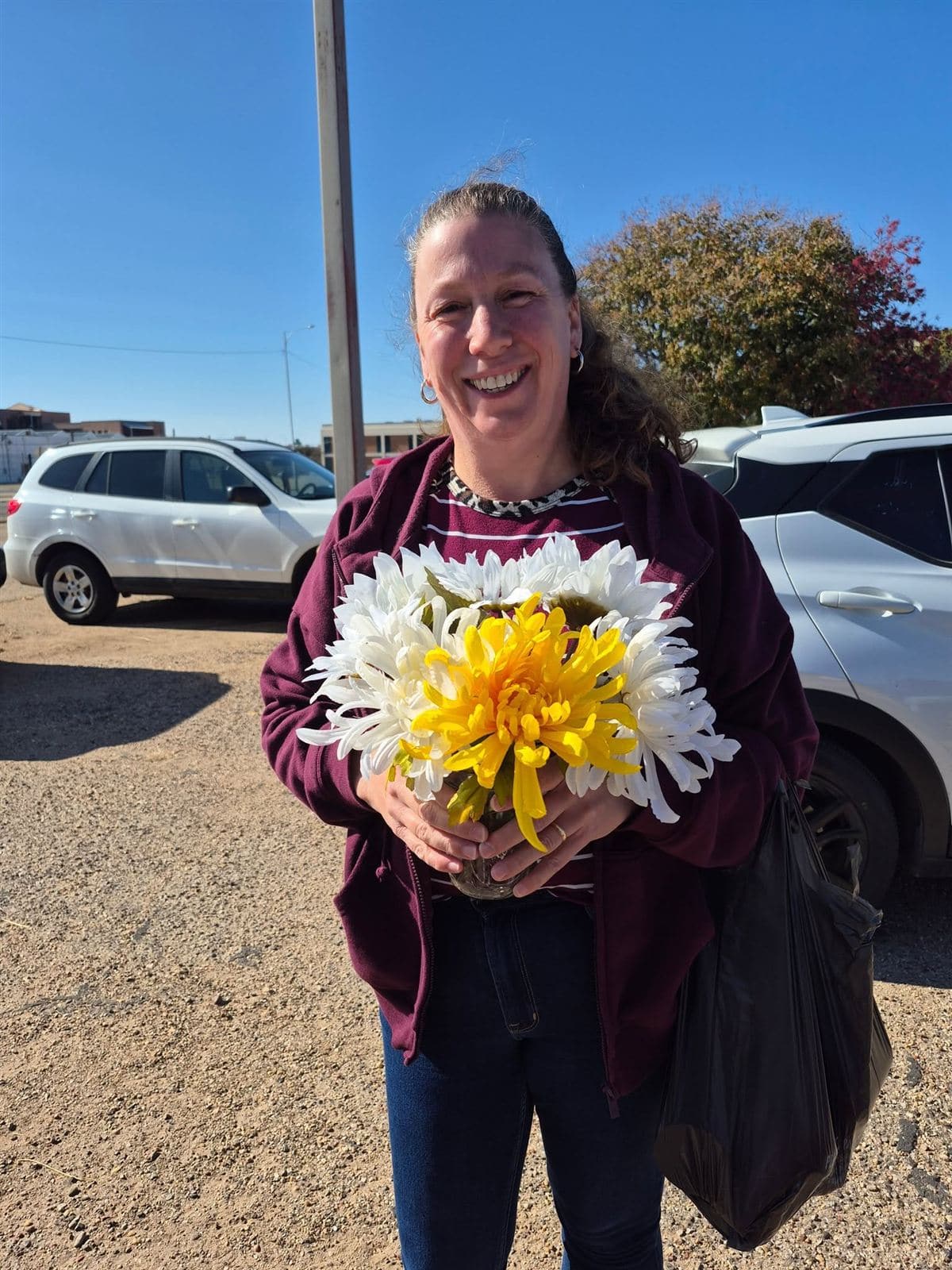 A neighbor holding a white and yellow bouquet