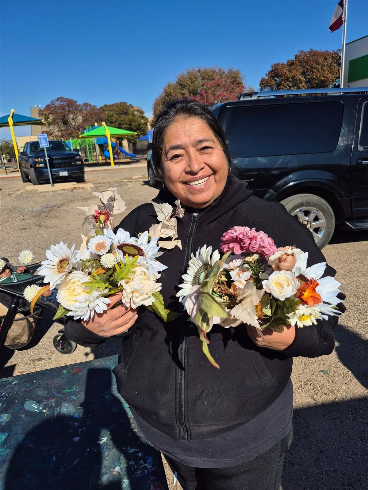 A neighbor beaming as she holds two bouquets