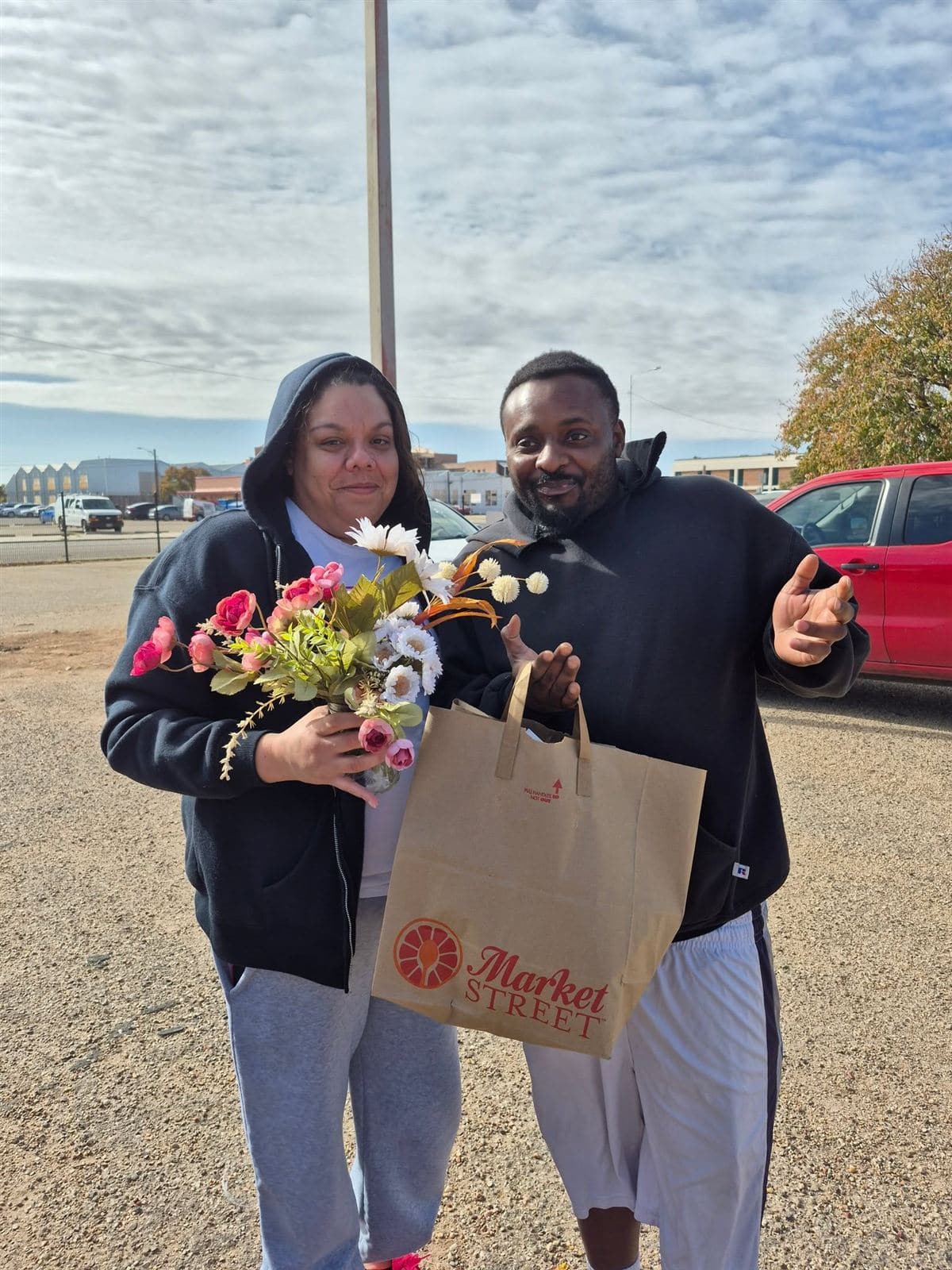 A couple with a bouquet and a grocery bag