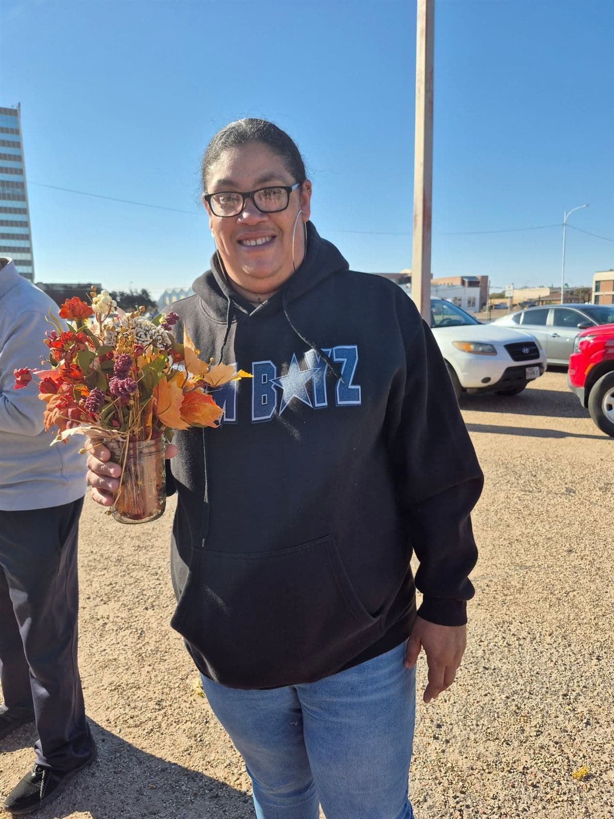 A neighbor in a Cowboys hoodie with a small fall bouquet