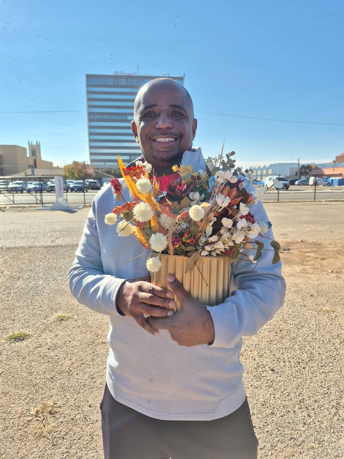 A neighbor smiling with a dried-flower arrangement