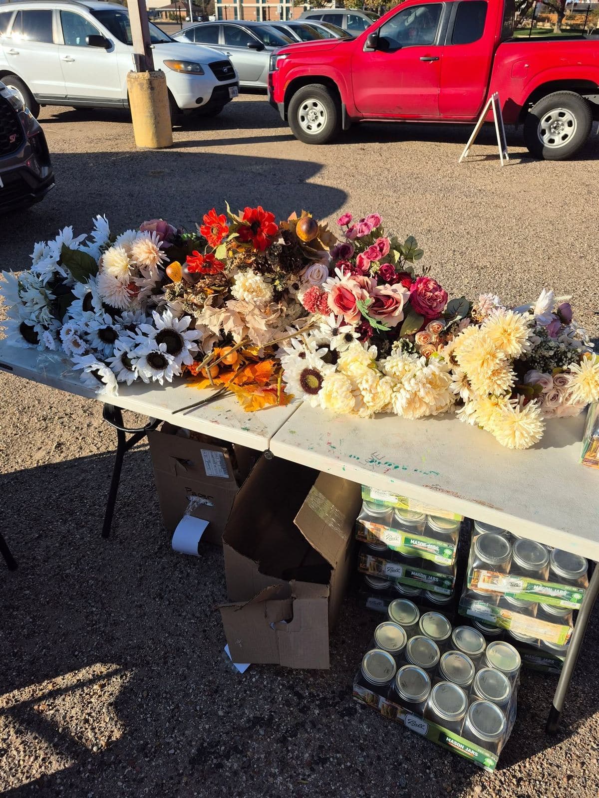 Flowers and cases of mason jars on the supply table