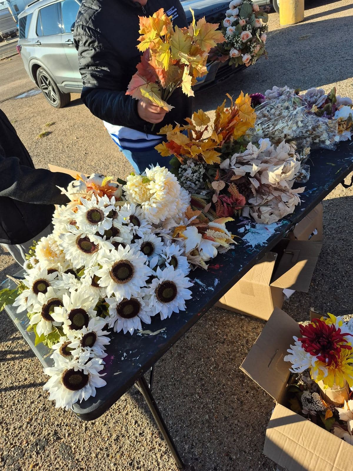 A supply table piled with sunflowers and fall stems at Heart for the Holidays 2025